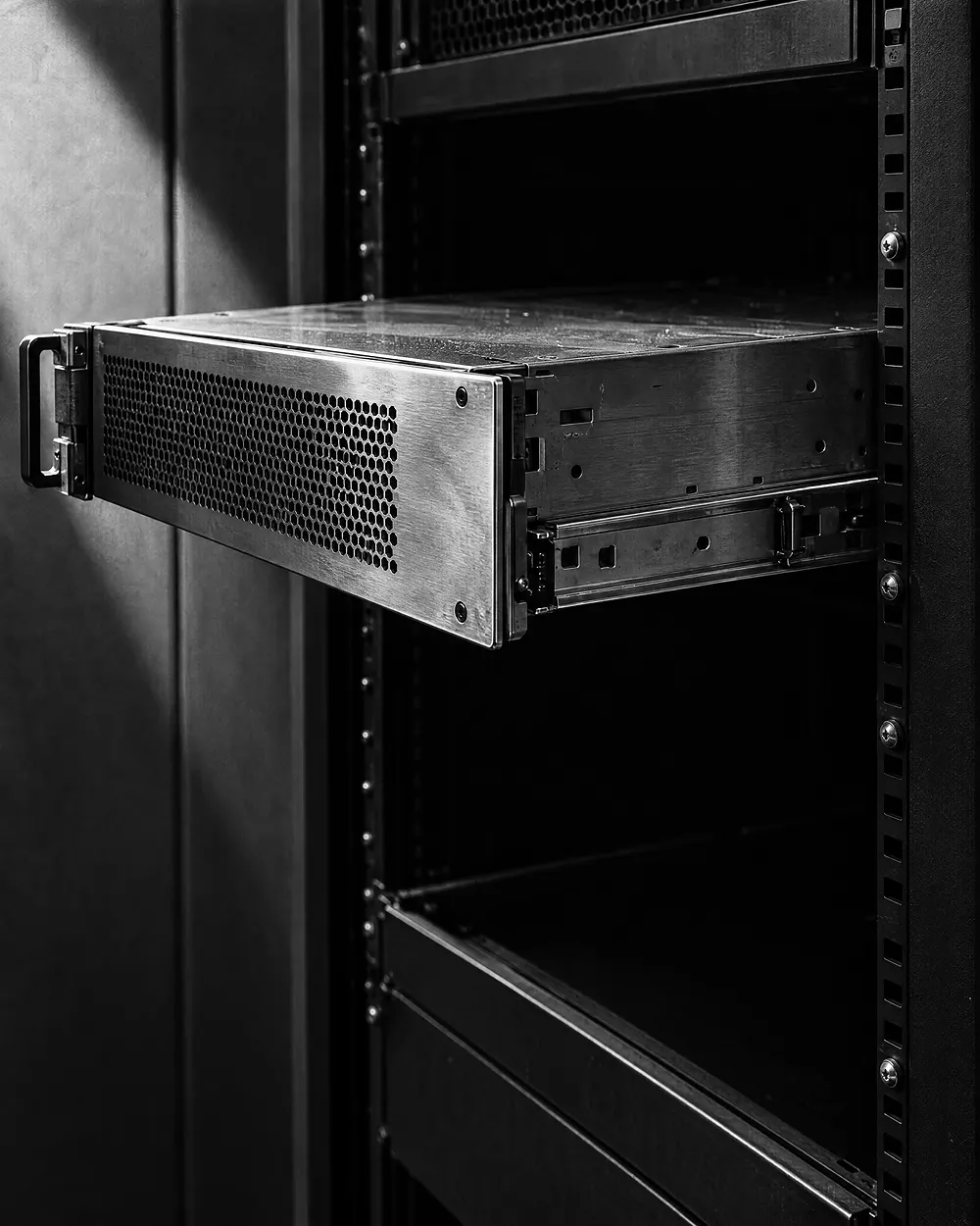 Ein einzelnes Servereinschub-Modul, halb aus dem Rack auf seinen Schienen gezogen, gebürstete Metallfront im harten Seitenlicht